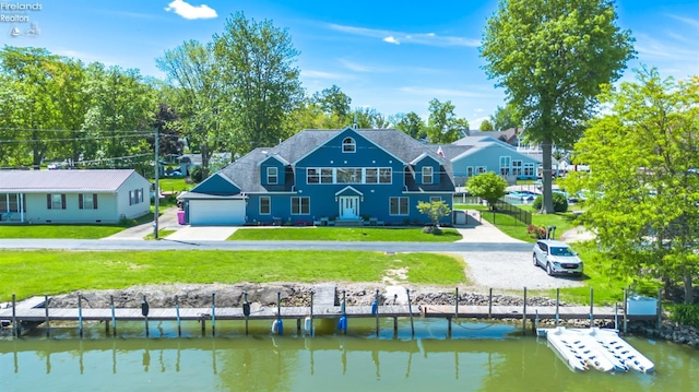 1909 N Nan Ave, Marblehead, OH 43440 - back of property featuring a garage, a lawn, a water view, and concrete driveway