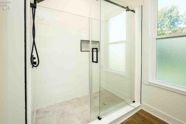 bathroom featuring a shower with shower door and hardwood / wood-style floors