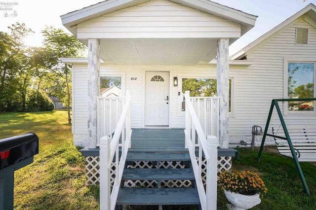 property entrance with a lawn