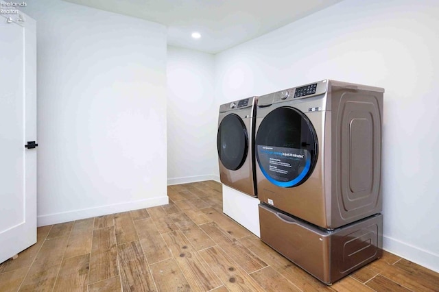 laundry room with light wood-type flooring and washing machine and dryer