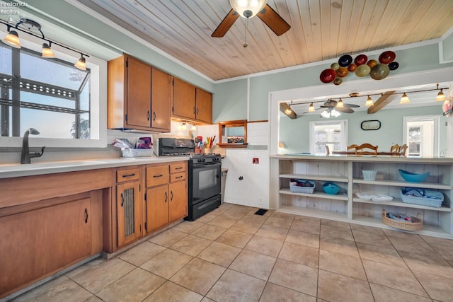 kitchen featuring backsplash, black range with gas cooktop, crown molding, sink, and ceiling fan