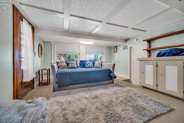 bedroom with coffered ceiling and light tile patterned floors