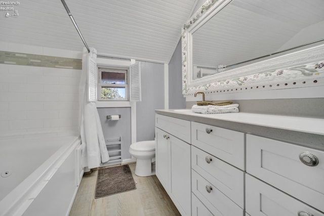 full bathroom with vanity, vaulted ceiling, hardwood / wood-style floors, toilet, and shower / bath combo