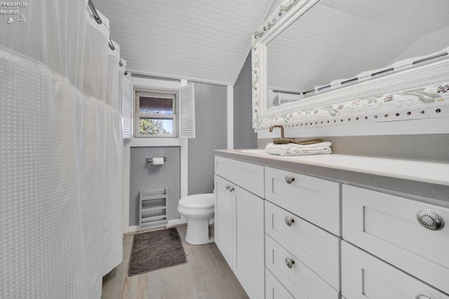 bathroom featuring lofted ceiling, vanity, toilet, and wood-type flooring