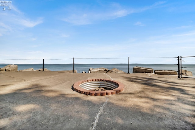 view of property's community featuring a water view and an outdoor fire pit