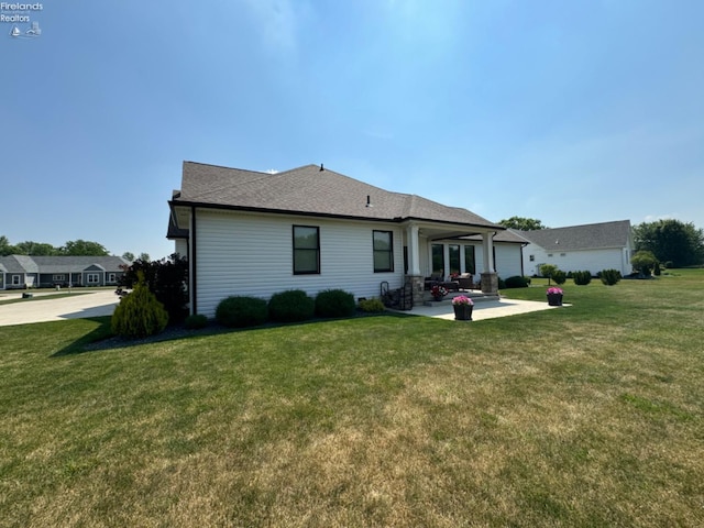 back of house featuring a patio area and a lawn