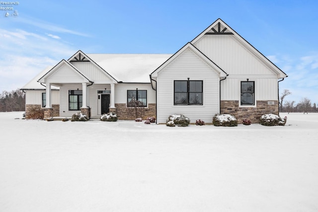 modern inspired farmhouse featuring stone siding and board and batten siding