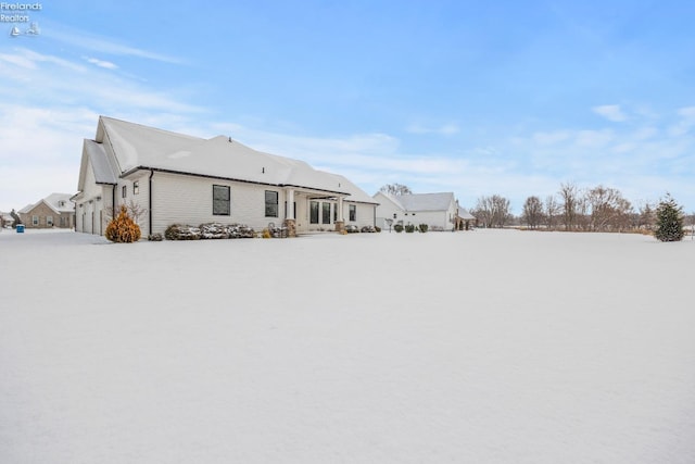 view of snow covered back of property