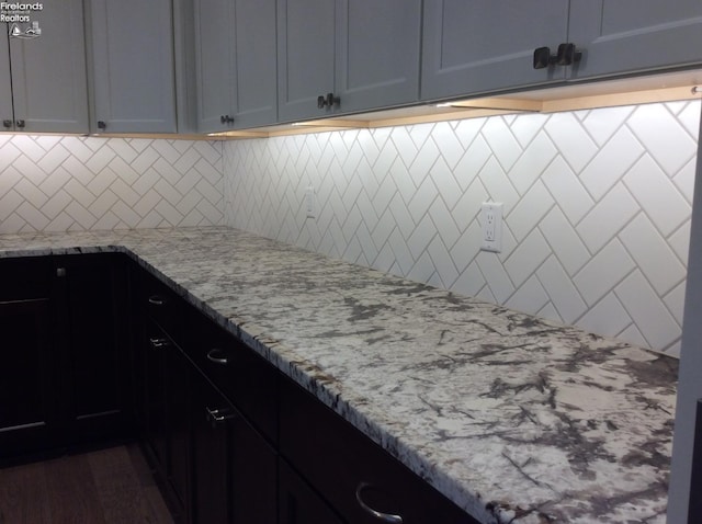 kitchen with light stone counters and decorative backsplash