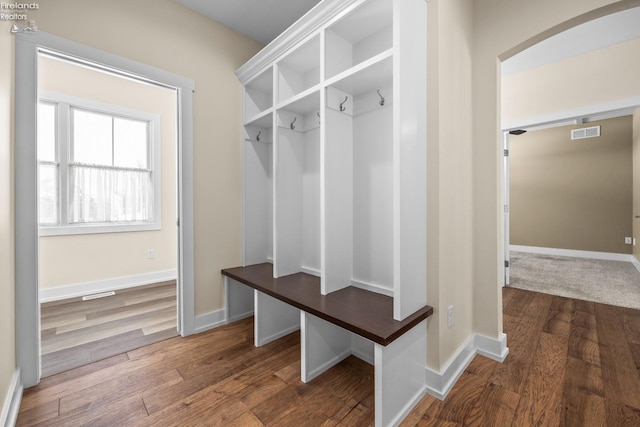 mudroom featuring visible vents, baseboards, and wood finished floors