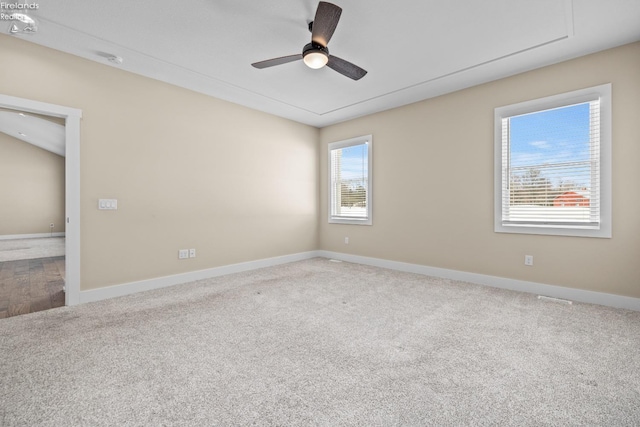 carpeted spare room featuring baseboards and ceiling fan