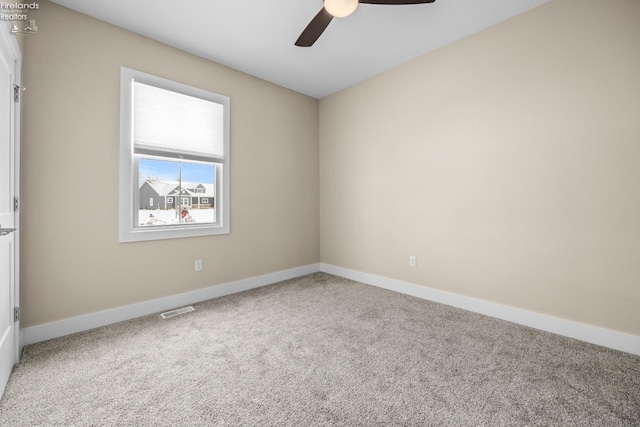 empty room featuring visible vents, carpet floors, baseboards, and a ceiling fan