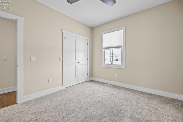 unfurnished bedroom featuring visible vents, a ceiling fan, a closet, carpet, and baseboards