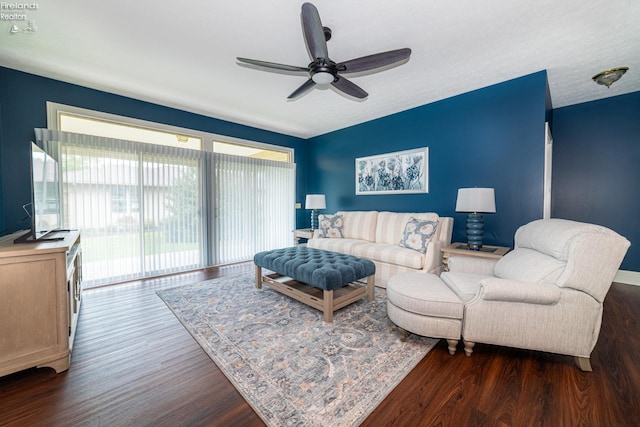 living room with dark wood-type flooring and ceiling fan