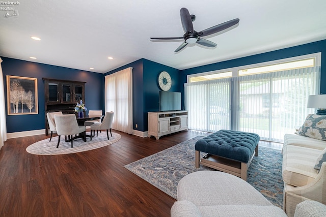 living room featuring dark wood-type flooring and ceiling fan