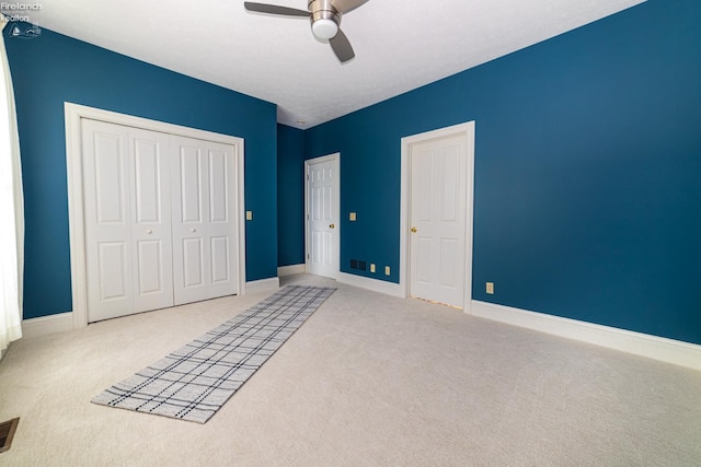 unfurnished bedroom with ceiling fan and light colored carpet