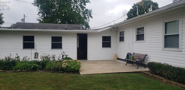 rear view of property with a yard and a patio area