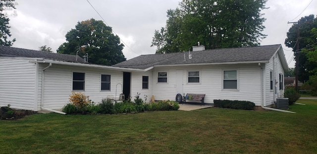 back of house with a lawn and central AC unit