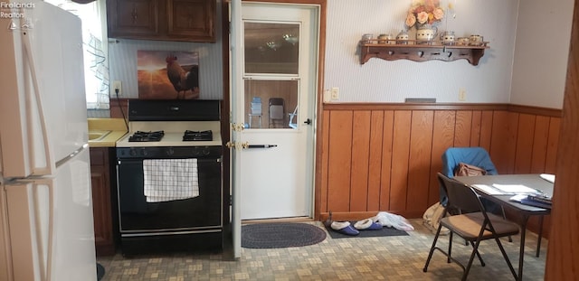 kitchen with white appliances and wooden walls