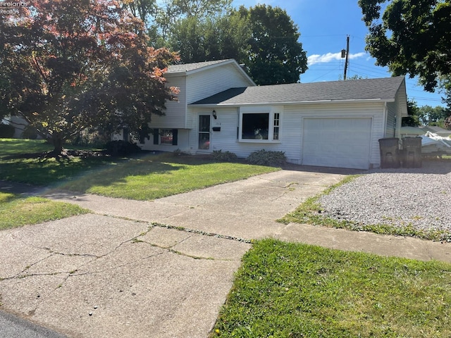 tri-level home with a garage and a front lawn