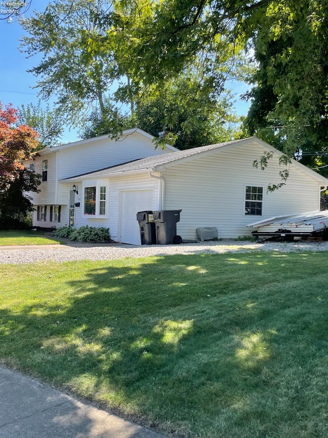 view of side of property featuring a garage and a yard