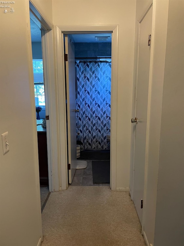 hallway with light colored carpet