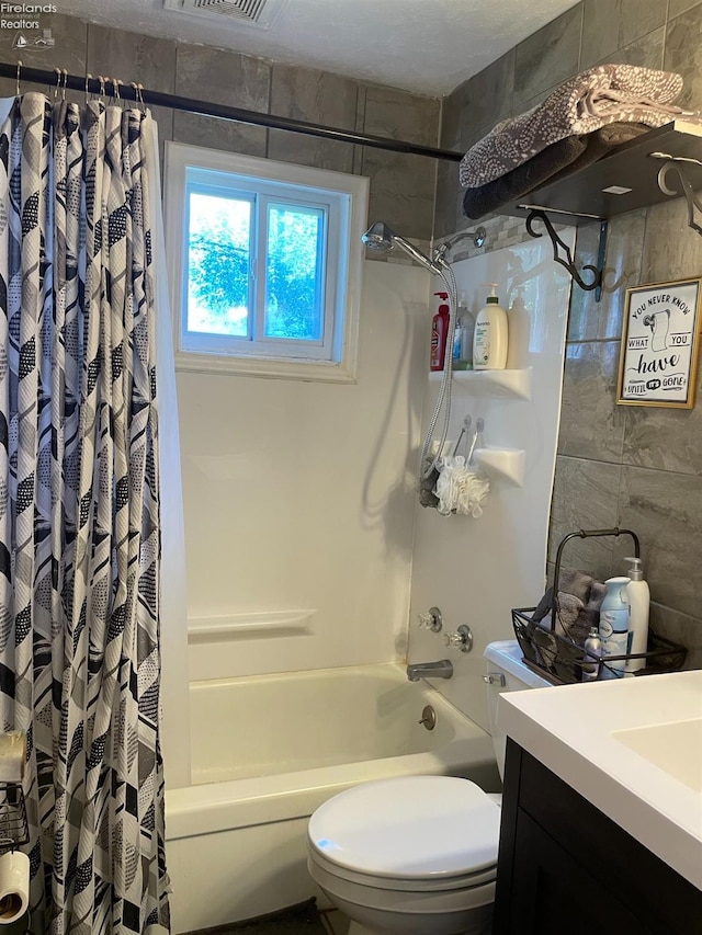 full bathroom with shower / tub combo with curtain, vanity, and toilet