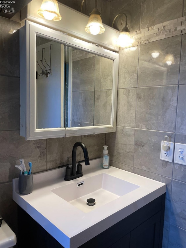 bathroom with tile walls, vanity, and tasteful backsplash