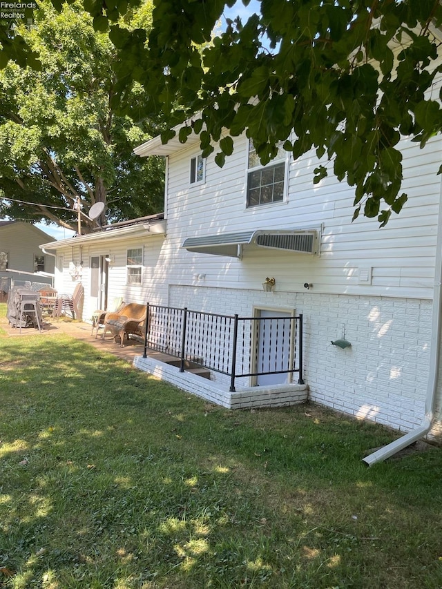 back of property featuring a patio and a yard