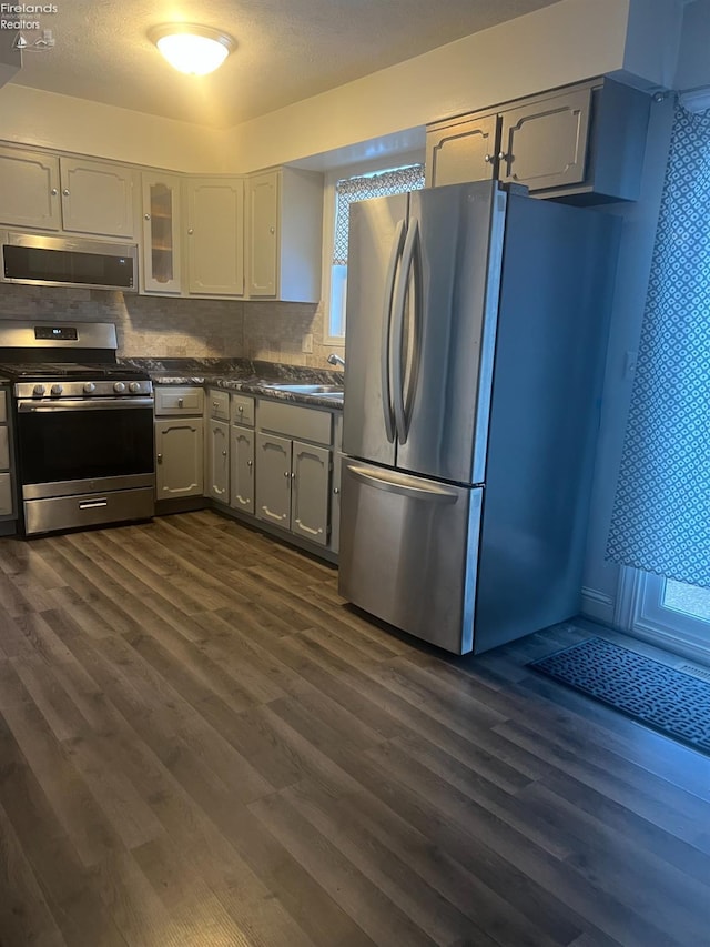 kitchen with dark wood-type flooring, stainless steel appliances, and gray cabinetry