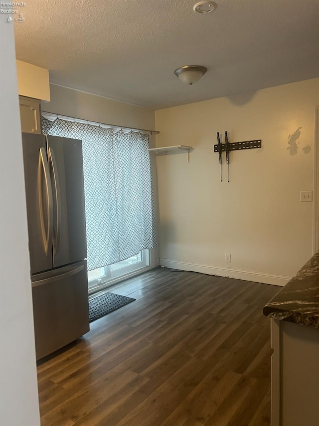 interior space featuring dark hardwood / wood-style floors, a textured ceiling, and stainless steel fridge