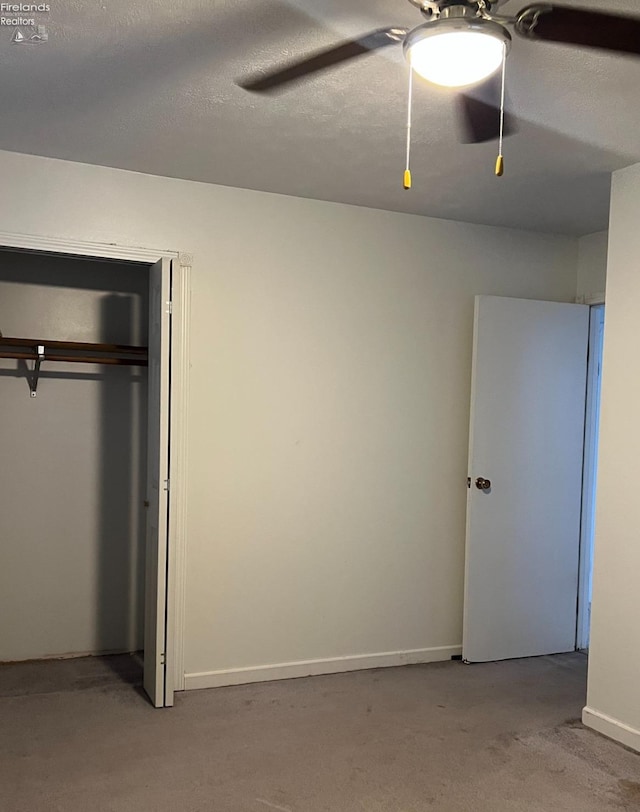 unfurnished bedroom featuring a textured ceiling, light carpet, ceiling fan, and a closet