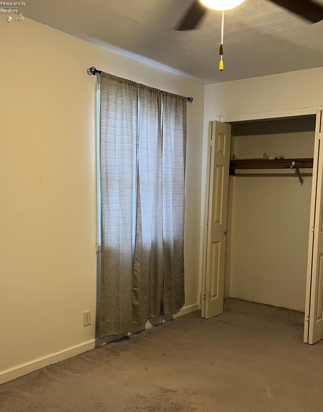 unfurnished bedroom with a closet, ceiling fan, and carpet flooring