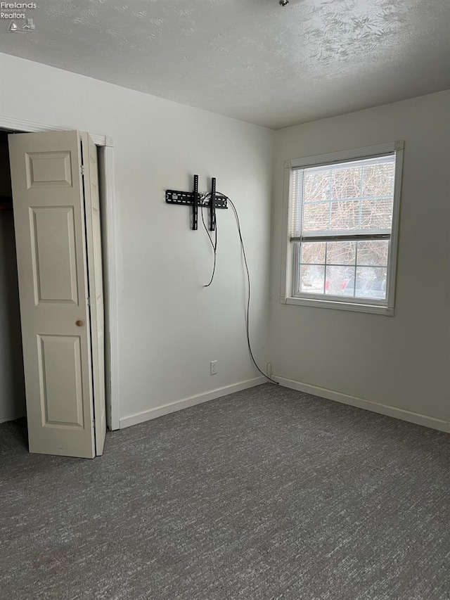 carpeted spare room featuring a textured ceiling