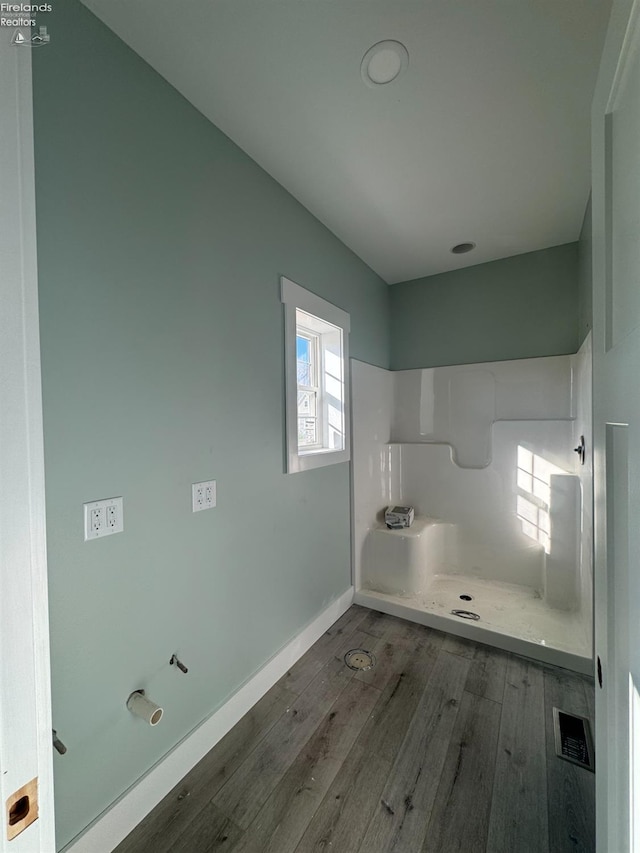 bathroom with a shower and hardwood / wood-style flooring