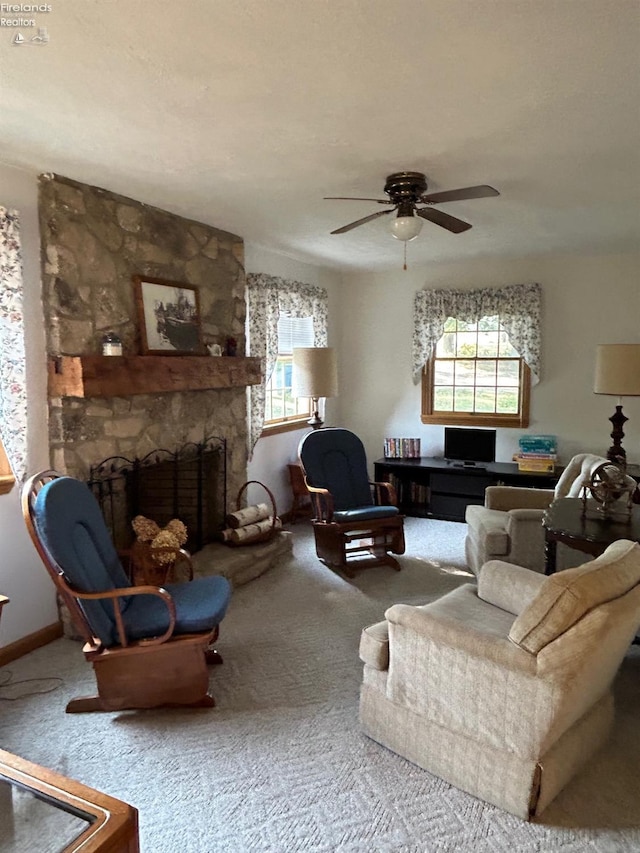 carpeted living room featuring a fireplace, a ceiling fan, and baseboards