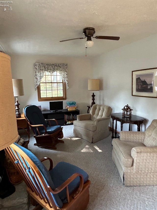 carpeted living area featuring a textured ceiling and a ceiling fan