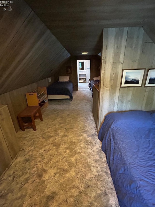 carpeted bedroom with wooden walls and lofted ceiling