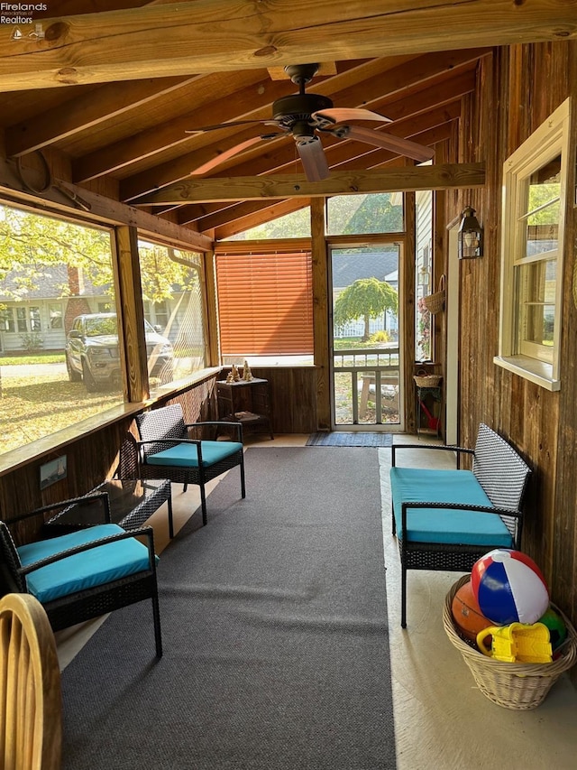 sunroom / solarium with lofted ceiling and a ceiling fan