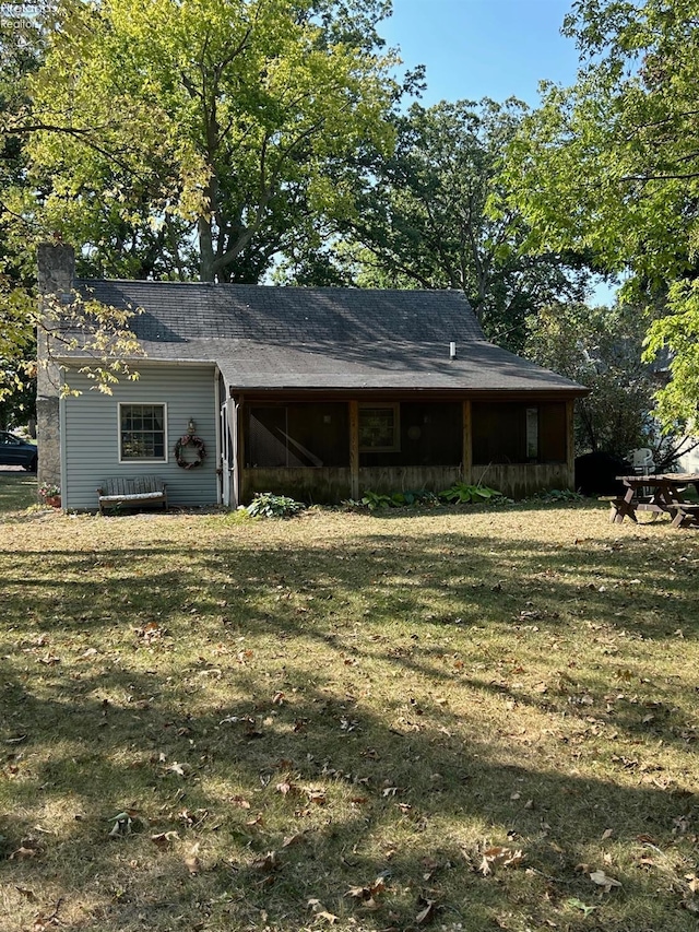 view of side of home with a lawn and a chimney