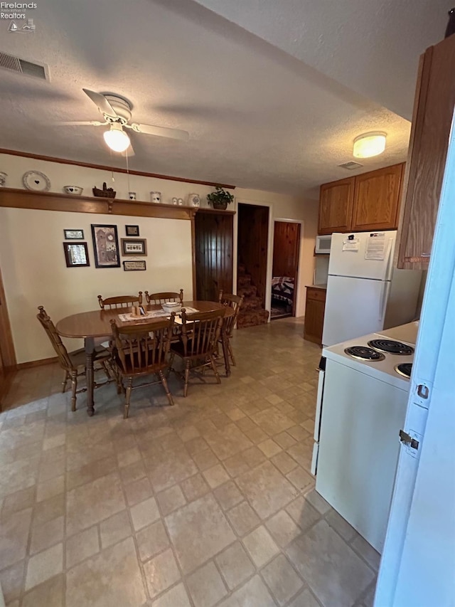 dining area with visible vents, a textured ceiling, and a ceiling fan