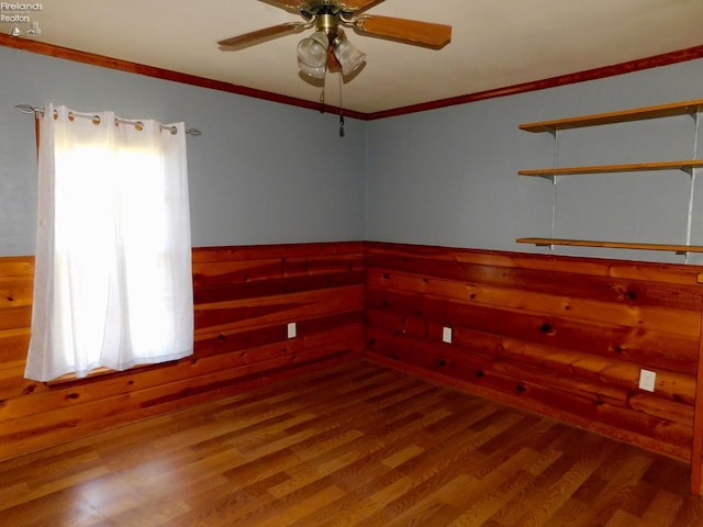 spare room featuring ceiling fan, ornamental molding, and wood-type flooring