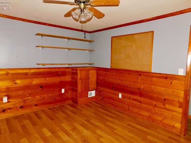 empty room featuring hardwood / wood-style floors, ceiling fan, and ornamental molding