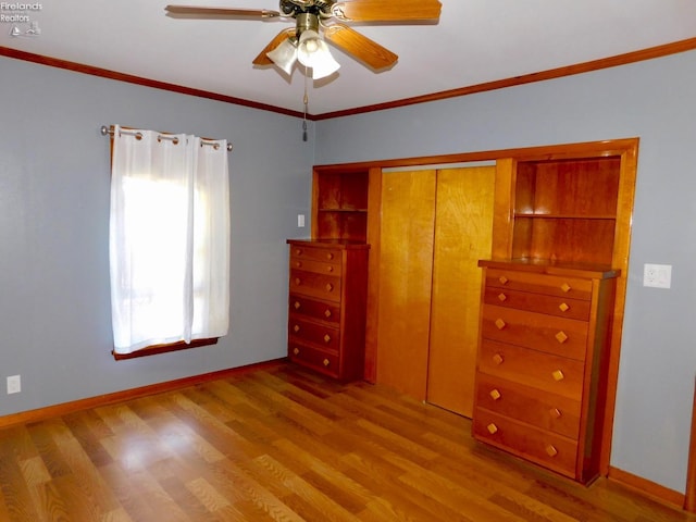 unfurnished bedroom featuring crown molding, ceiling fan, a closet, and wood-type flooring