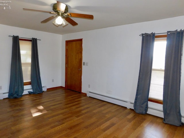 empty room with dark wood-type flooring, ceiling fan, and a baseboard radiator