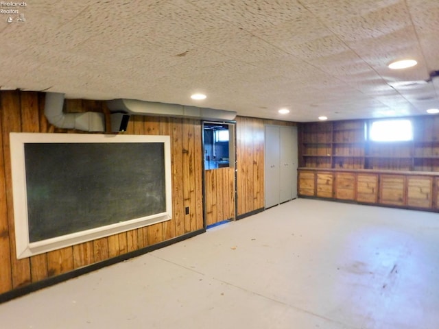 basement featuring wood walls