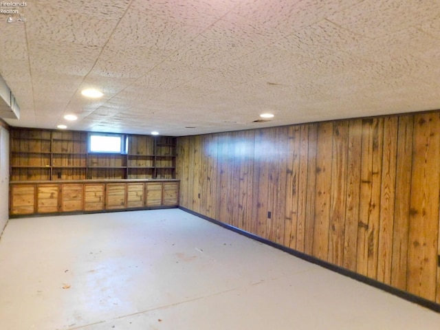 basement featuring wooden walls