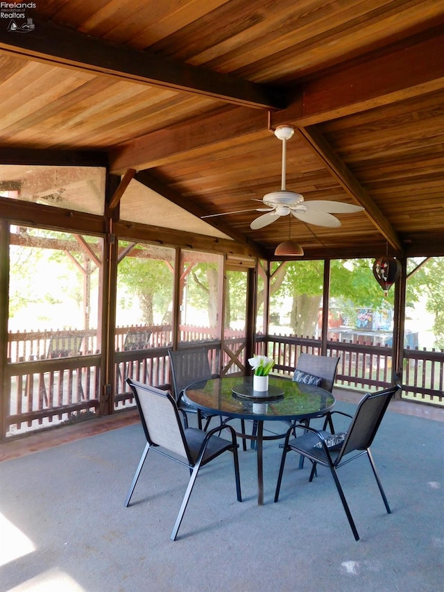 unfurnished sunroom with wood ceiling, plenty of natural light, and vaulted ceiling with beams