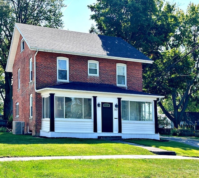 view of front of property with a front lawn and cooling unit