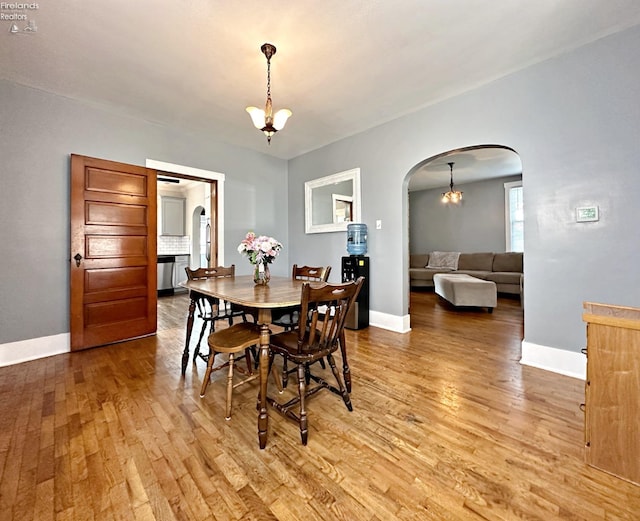 dining room with light hardwood / wood-style flooring and a notable chandelier